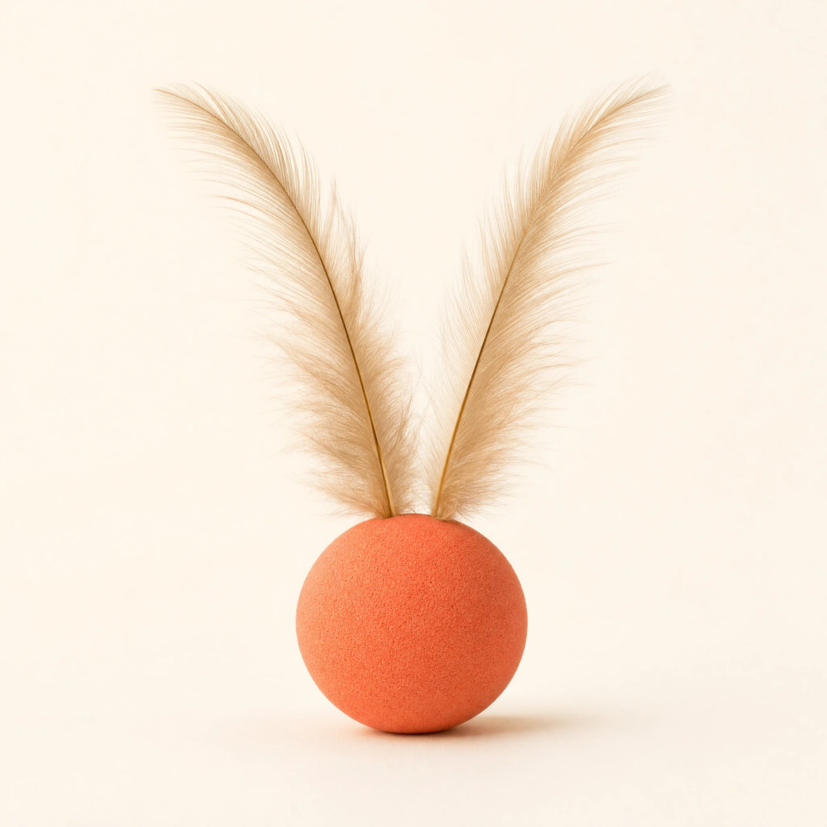Feather Ball Pet Toy: coral-orange foam ball with two natural feathers